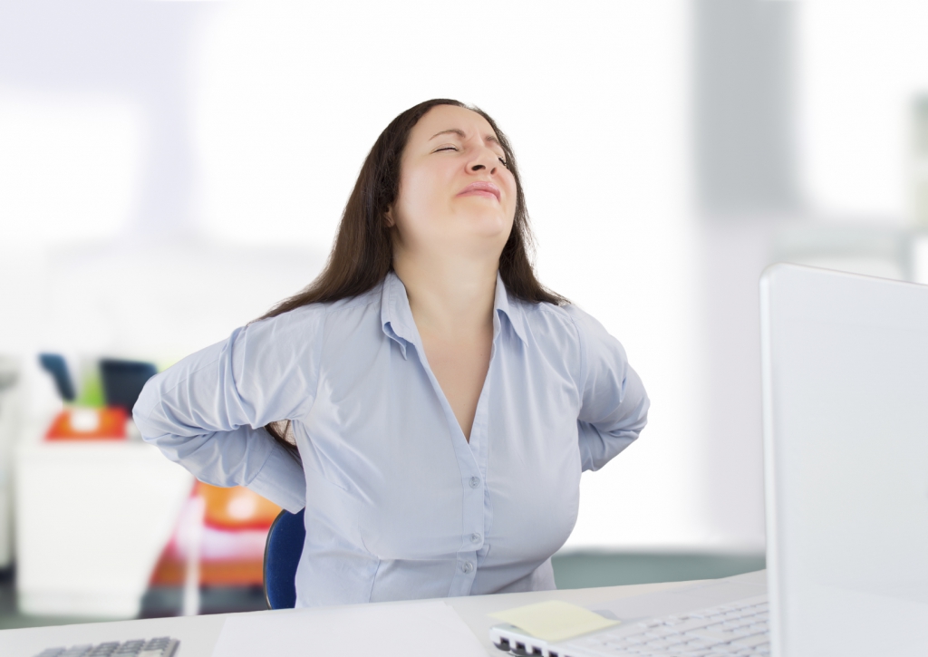 business woman with a strong backache in the workplace