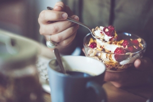 Young woman is eating breakfast cereal